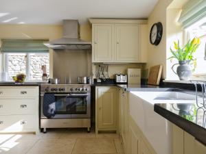 a kitchen with a stove and a sink at Hungate Garden Cottage in Pickering