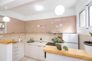 a kitchen with white cabinets and a white refrigerator at GALIOT Apartment in Škaljari +10 photos