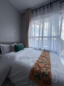 ein Schlafzimmer mit einem großen Bett mit einem großen Fenster in der Unterkunft Solara Loft in Nairobi