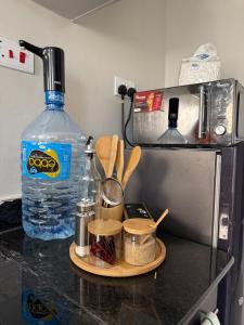 eine Küchentheke mit einer Flasche Wasser und etwas Besteck in der Unterkunft Solara Loft in Nairobi