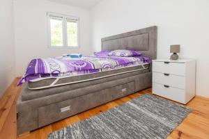a bedroom with a large bed and a white dresser at GALIOT Apartment in Škaljari
