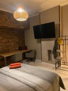 a bedroom with a bed and a flat screen tv at Suite Blanche in Ostend