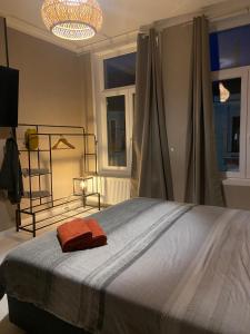 a bedroom with a bed with a red towel on it at Suite Blanche in Ostend