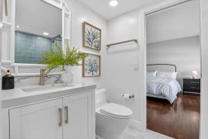 a bathroom with a toilet and a sink and a bed at Direct Oceanfront Three-Bedroom Luxury Apartment with Large Terrace in South Palm Beach