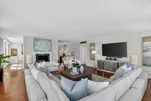 a living room with a couch and a tv at Direct Oceanfront Three-Bedroom Luxury Apartment with Large Terrace in South Palm Beach