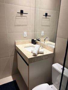 a bathroom with a sink and a toilet and a mirror at Modern apartment - Cittyplex in Osasco