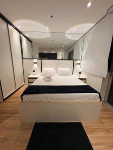 a large white bed in a room with two lamps at Modern apartment - Cittyplex in Osasco +29 photos