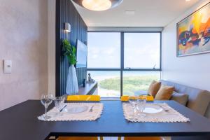 a dining room with a blue table with wine glasses at BHS Flat a beira mar 2105 in Recife