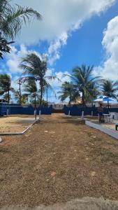 ein Park am Strand mit Palmen und dem Meer in der Unterkunft Casa de praia com área de lazer in Nísia Floresta + 7 Fotos