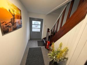 een gang met trap met een schilderij van een hert aan de muur bij Ferienwohnungen Bella in Reutte