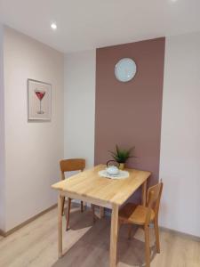 ein Esszimmer mit einem Holztisch und Stühlen in der Unterkunft Parenthèse Vosgienne in Cornimont