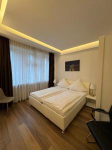 a bedroom with a large white bed and a window at Boardinghouse Rosenstraße in Hamburg