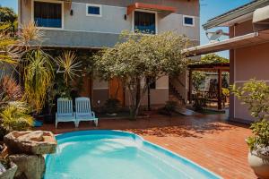 a swimming pool in front of a house at Pousada Nanai in Foz do Iguaçu