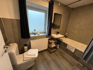 a bathroom with a toilet and a tub and a sink at Ferienwohnungen Bella in Reutte