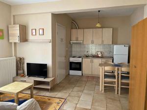 a kitchen with white appliances and a table in it at Feels like home in Maniákoi