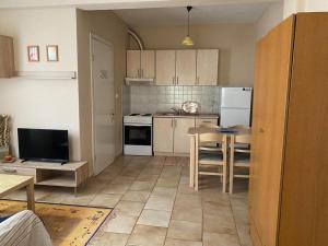 a kitchen with white appliances and a table in it at Feels like home in Maniákoi