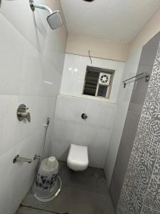 a small bathroom with a toilet and a window at Heaven's Crest in Chennai