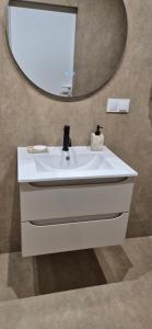 ブスコ・ズドロイにあるSłoneczny Ogródekの白い洗面台と鏡のあるバスルーム +19枚の写真