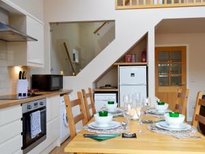 a kitchen with a table with wine glasses on it at Birch Tree Cottage in Edzell