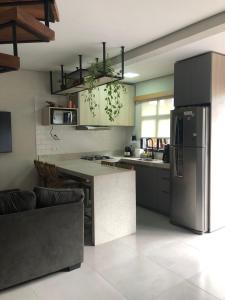 eine Küche mit einem Kühlschrank und einem Tisch darin in der Unterkunft Palulu Flat Juquehy - O refúgio perfeito para casais e famílias - Área de Lazer com Piscina e Sauna - Garagem Subterrânea - Serviço de Praia in Juquei