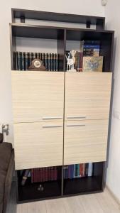 a large wooden dresser in a room with books at Apartament Complex Rezidential Magnolia Bariera Valcii in Craiova