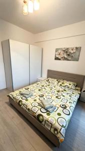 a bedroom with a bed with a colorful comforter at Apartament Complex Rezidential Magnolia Bariera Valcii in Craiova