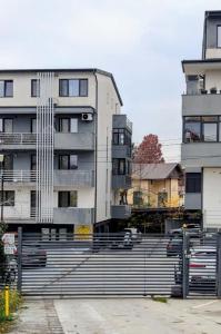 a tall building with cars parked in front of it at Apartament Complex Rezidential Magnolia Bariera Valcii in Craiova