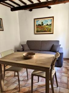 a living room with a wooden table and a couch at Alloggio Turistico LA TORRE in Acquapendente +6 photos