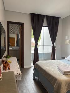 a bedroom with a bed and a bathroom with a window at Casa Privativa Prox Expoville e Centro Com 2 Suítes in Joinville