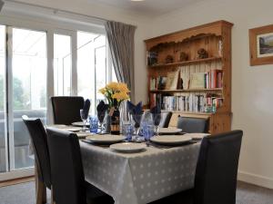 a dining room table with chairs and a table cloth at Hillside Cottage in Keswick