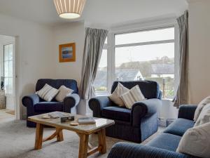 a living room with two blue chairs and a coffee table at Hillside Cottage in Keswick