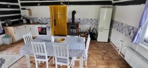 a kitchen with a table and chairs in a kitchen at Poloroubenka Podkrkonoší in Bělá
