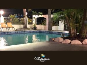a swimming pool in a resort with chairs and trees at Matasawa Resort - Wailoaloa, Nadi in Nadi