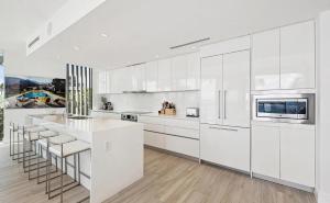パーム・ビーチ・ショアーズにあるCozy Three-Bedroom Waterfront Apartment with Scenic Viewsの白いキッチン(白いキャビネット、カウンター付)