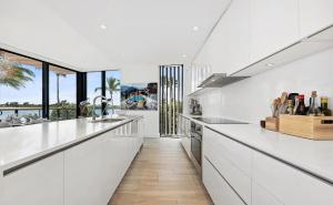 パーム・ビーチ・ショアーズにあるCozy Three-Bedroom Waterfront Apartment with Scenic Viewsのキッチン(白いカウンター、大きな窓付)