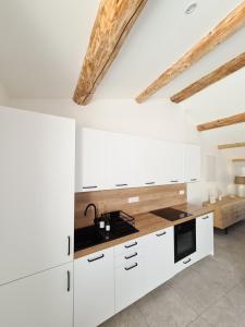 uma cozinha com armários brancos e uma bancada em LE ROOFTOP PROVENÇAL em Taulignan