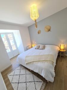 a white bedroom with a large bed and a chandelier at LE ROOFTOP PROVENÇAL in Taulignan +55 photos