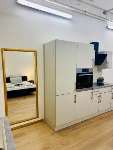 オルデンブルクにあるZentrales Studio Apartmentのキッチン(鏡付)、ベッド1台が備わります。 +4枚の写真
