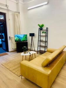 オルデンブルクにあるZentrales Studio Apartmentのリビングルーム(黄色のソファ、テレビ付)