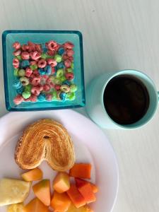 a plate with a box of cereal and a cup of coffee at Hotel Mirador--gratis bicicletas in Bacalar