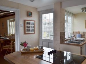 eine Küche mit Tisch und Arbeitsplatte in der Unterkunft Garden Cottage in Rottingdean