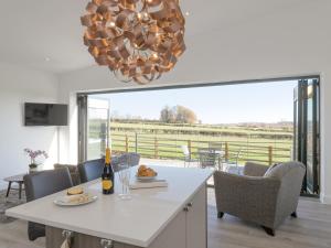 eine Küche und ein Esszimmer mit einem Tisch und einem Kronleuchter in der Unterkunft The Hideaway -Ukc3844 in Ticknall