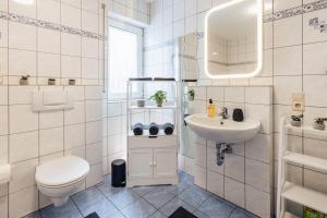 メンディヒにあるVulkan-Suiteのトイレと洗面台を備えた白いバスルーム