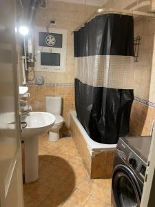 ein Badezimmer mit einer Badewanne, einem Waschbecken und einer Waschmaschine in der Unterkunft El Rehab city in New cairo