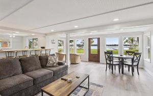 a living room with a couch and a table at Lakefront Escape Dock Fire Pit Sleeps 14 in Gaylord