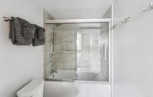 a shower with a glass door in a bathroom at Lakefront Escape Dock Fire Pit Sleeps 14 in Gaylord +51 photos