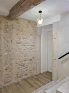 um quarto com uma parede de pedra e um lustre em LE ROOFTOP PROVENÇAL em Taulignan