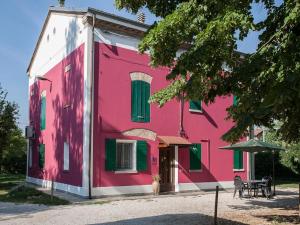 a pink building with a dog in front of it at Villa Camurana in Medolla
