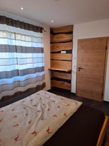 a bedroom with a bed and a wooden door at Chalet Ausweger - Strobl am Wolfgangsee in Strobl