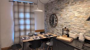 a kitchen with a table and chairs and a stone wall at Arc1950 Prince Des Cimes appt 4-5 pers ski in out piscine intérieure in Arc 1950
